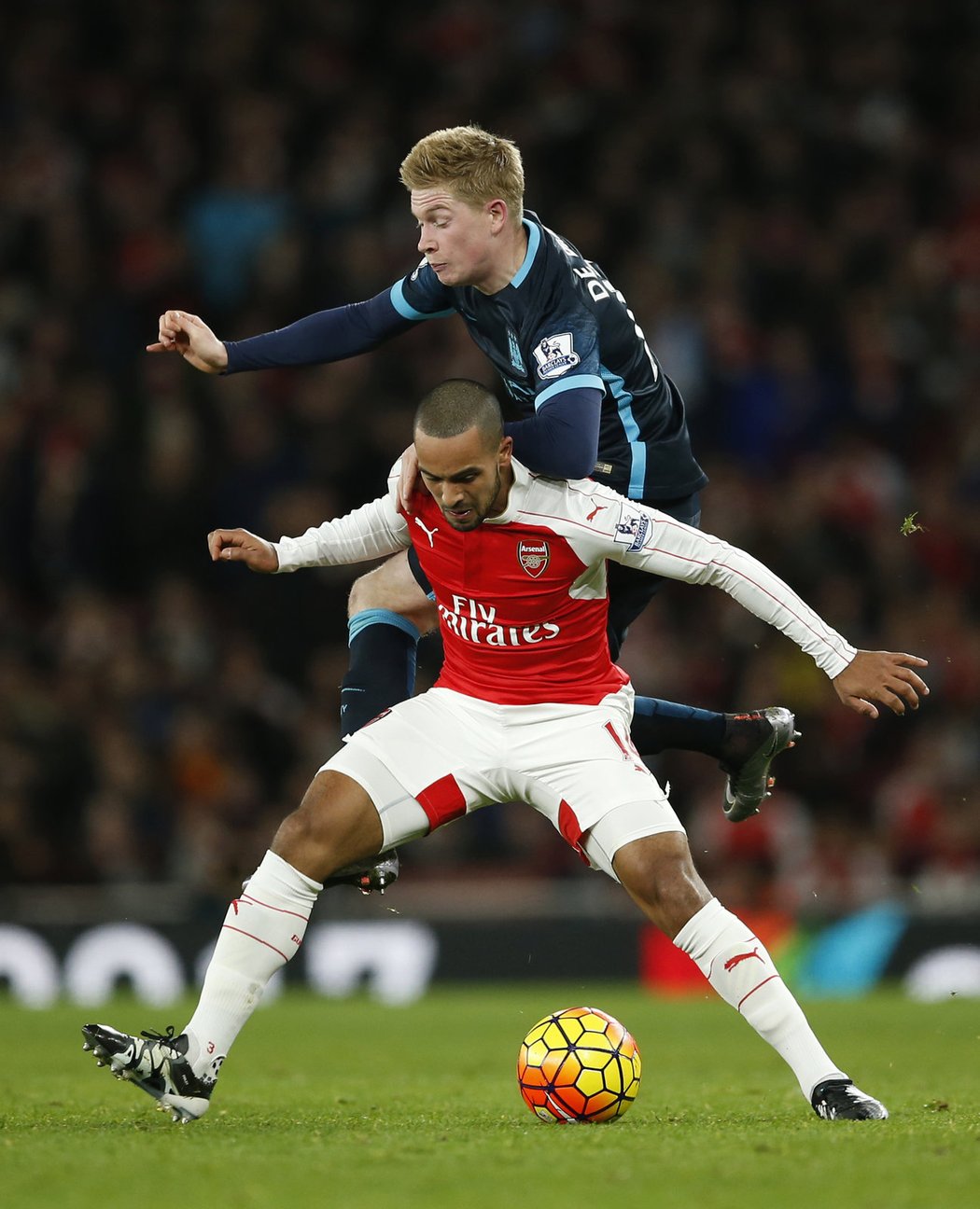 Kevin de Bruyne v souboji s Theo Walcottem (dole)