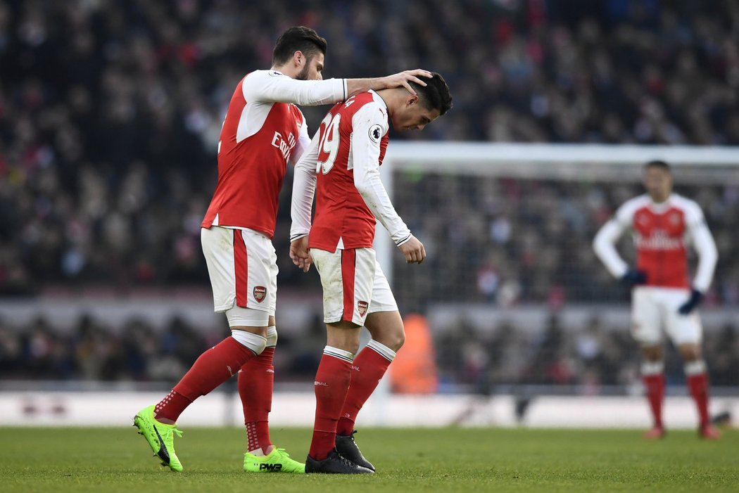 Olivier Giroud utěšuje spoluhráče z Arsenalu Granita Xhaku po Švýcarově vyloučení