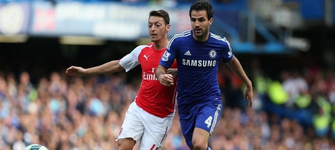 Mesut Özil z Arsenalu v souboji s Cescem Fábregasem z Chelsea