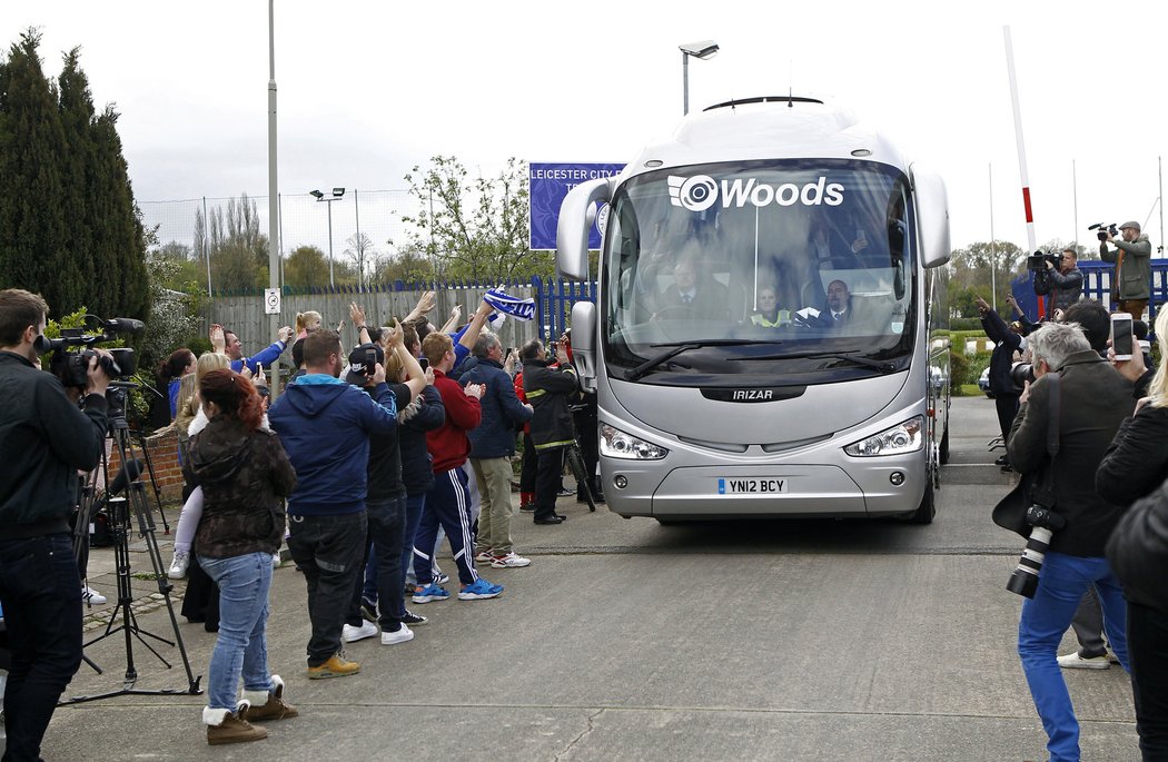 Fanoušci Leicesteru mávají směrem k autobusu, který ke hřišti přivezl anglické šampiony