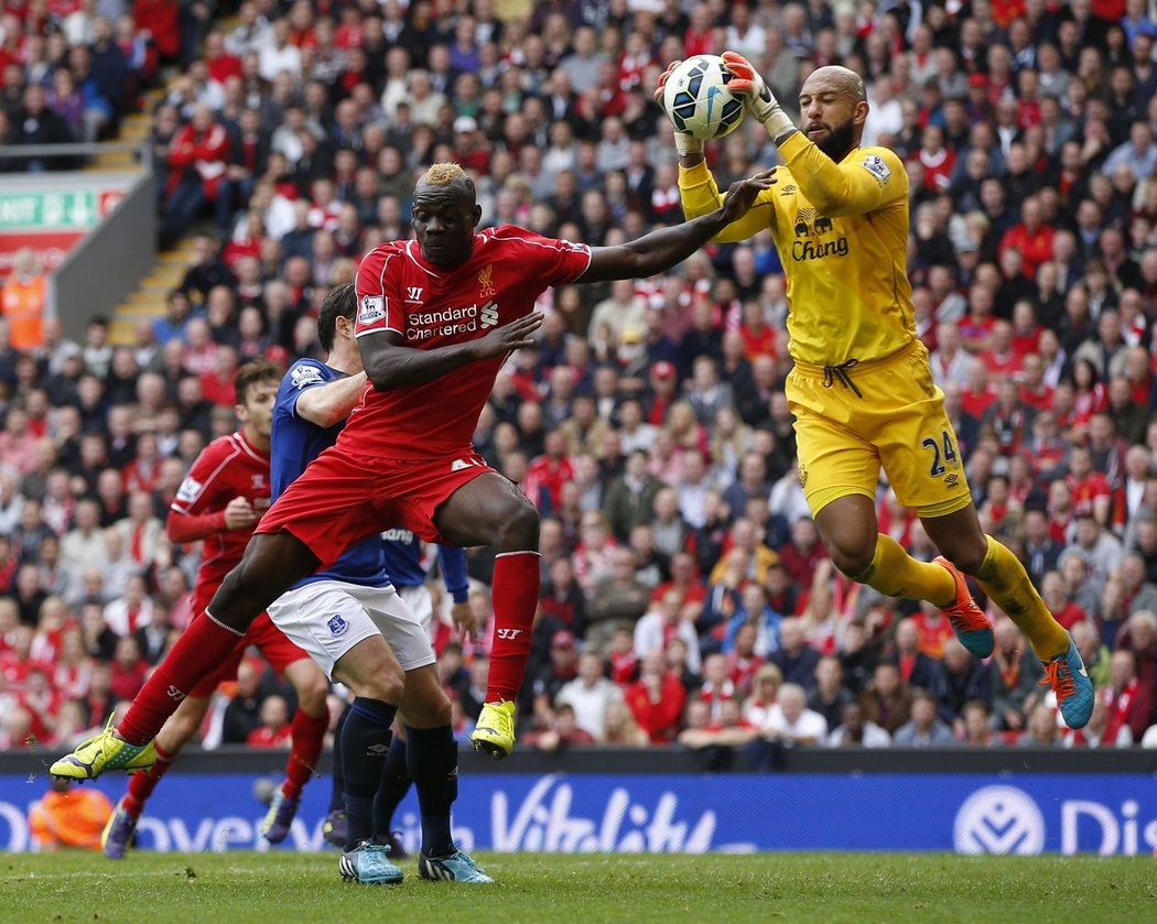 Liverpoolský útočník Mario Balotelli v souboji s gólmanem Timem Howardem.