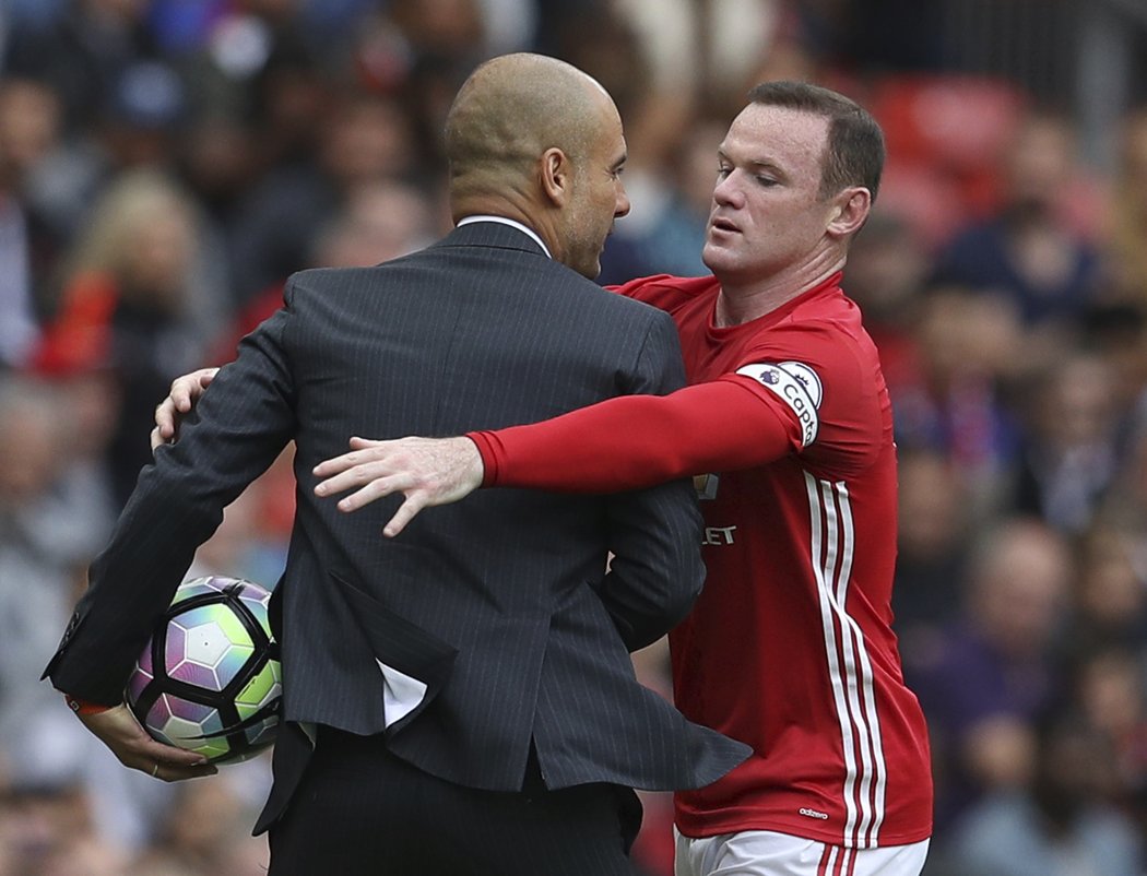 Kapitán Manchesteru United Wayne Rooney se sápe po trenérovi Citizens Pepu Guadiolovi během derby v Premier League