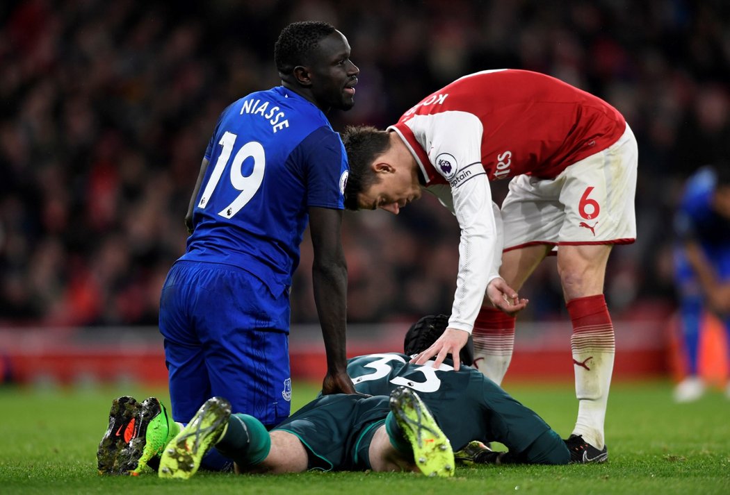 Brankář Petr Čech, nad nímž se sklání Oumar Niasse z Evertonu a spoluhráč Laurent Koscielny