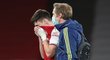 Zraněný Kieran Tierney opouští trávník během zápasu Arsenalu s Liverpoolem