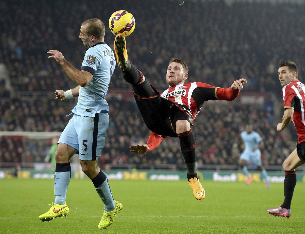 Connor Wickham ze Sunderlandu odkopává míč před Pablo Zabaletou ze City