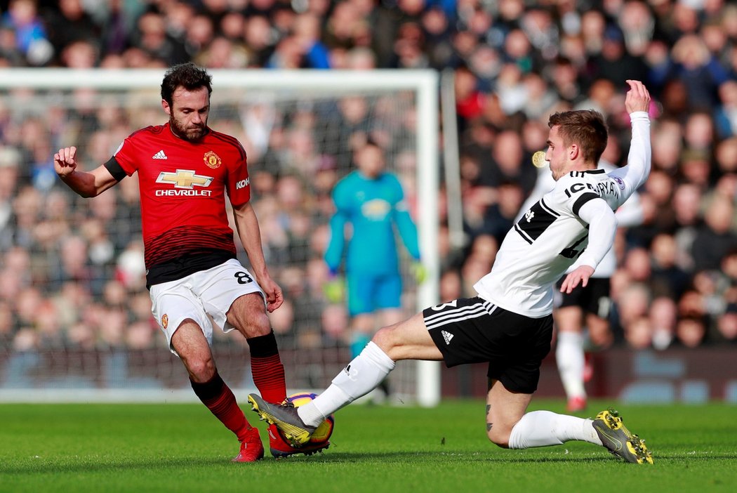 Ostrý souboj o míč předvedli v utkání Fulham - Manchester United domácí obránce Joe Bryan a Juan Mata