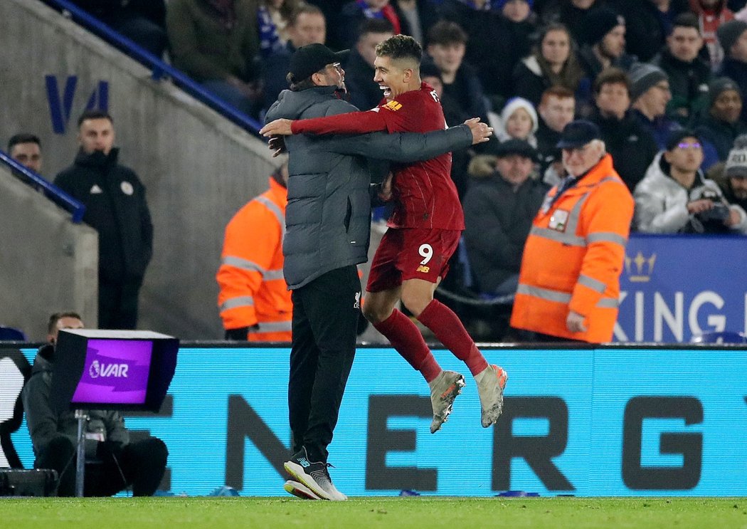 Střelec Roberto Firmino skáče do náruče kouče Kloppa