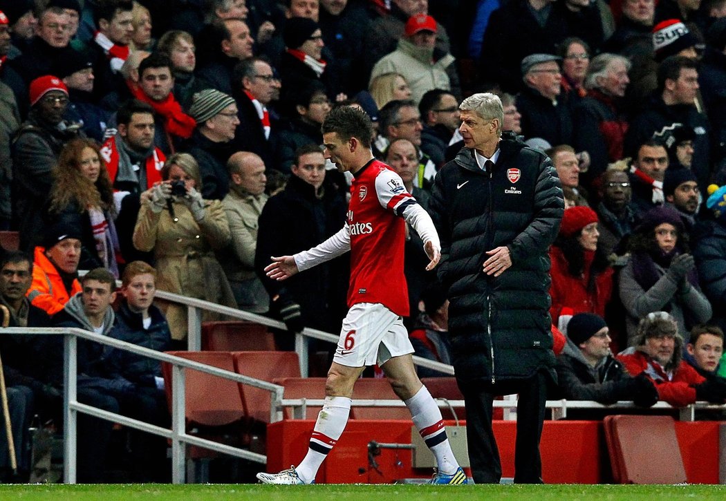 Naštvaný Laurent Koscielny míjí kouče Wengera poté, co byl v duelu s Manchesterem City vyloučen
