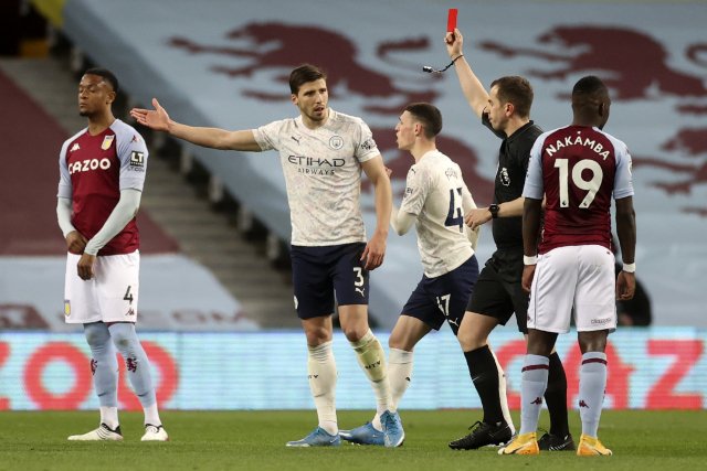 Ruben Dias (uprostřed) gestikuluje po vyloučení Johna Stonese během duelu s Aston Villou