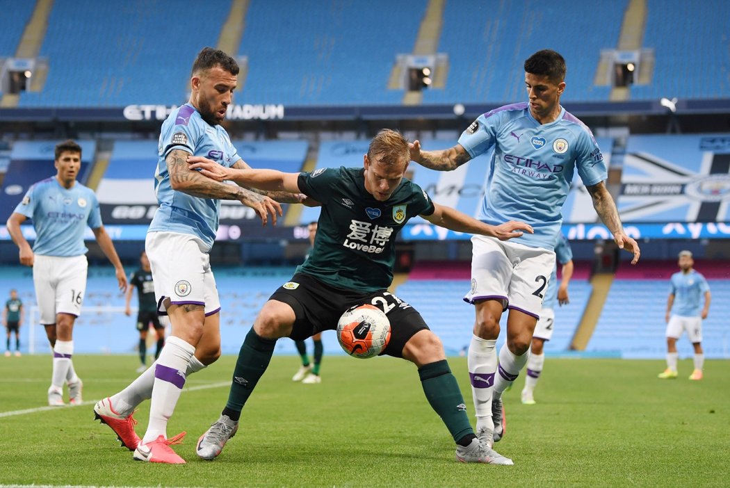 Český útočník Burnley Matěj Vydra se snaží získat balon v utkání s Manchesterem City