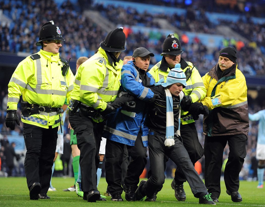 Chuligán hlásící se k Manchesteru City již byl spacifikován strážci pořádku a je odváděn z hrací plochy