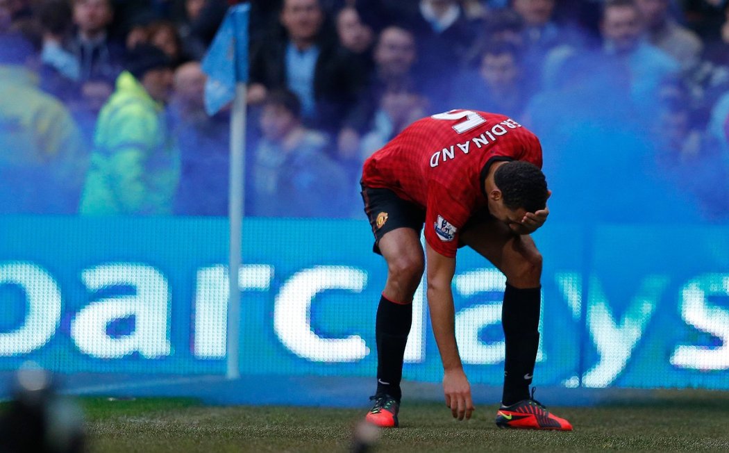 Stoper Manchesteru United Rio Ferdinand se drží za hlavu. Do ní jej zasáhl jeden z předmětů, kteří vhodili fandové Manchesteru City na konci derby na hřiště