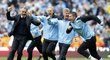 Kouč Manchesteru City Roberto Mancini (vlevo) vbíhá na trávník slavit mistrovský titul, který jeho tým zachránil dvěma brankami v nastaveném čase
