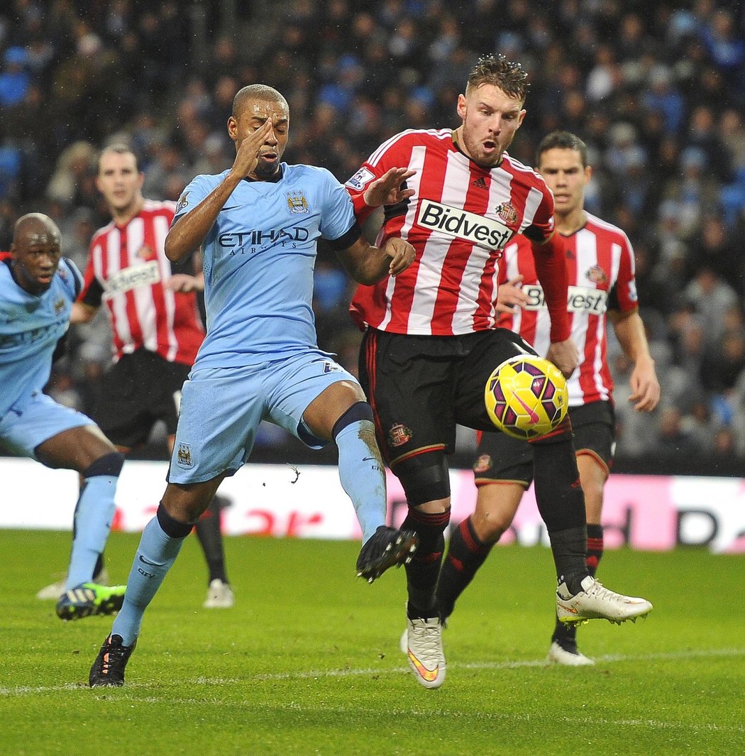 Fernandinho bojuje s Wickhamem o míč