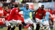 Křídelník Raheem Sterling z Manchesteru City v obležení protihráčů United v městském derby