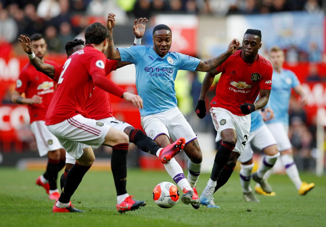 Křídelník Raheem Sterling z Manchesteru City v obležení protihráčů United v městském derby