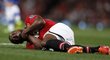 Patrice Evra z Manchesteru United se svíjí bolestí po souboji s hráči Chelsea