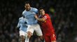 Liverpoolský střelec Luis Suárez se dere za míčem, v pozadí jej atakuje obránce Manchesteru City Kompany