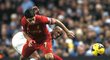 Liverpoolský střelec Luis Suárez se dere za míčem, v pozadí jej atakuje obránce Manchesteru City Kompany