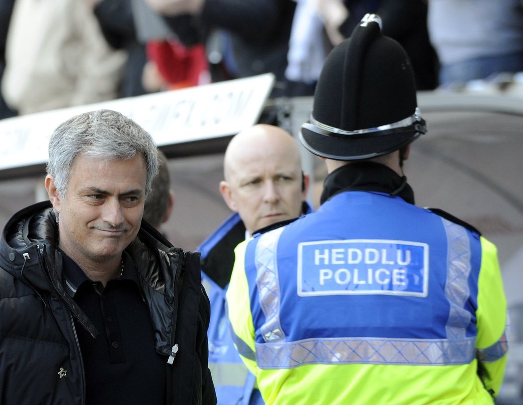 Trenér Chelsea José Mourinho pod dohledem strážců pořádku při utkání na půdě Swansea