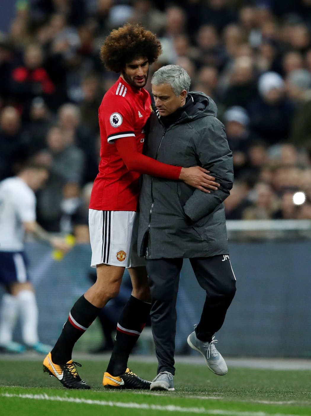 Trenér Manchesteru United José Mourinho utěšuje záložníka Fellainiho poté, co krátce po příchodu na trávník v utkání s Tottenhamem musel kvůli zranění kolene střídat