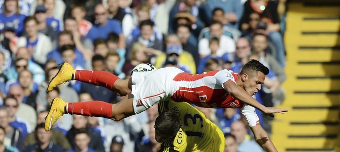 Gólman Chelsea Thibaut Courtois při srážce s útočníkem Arsenalu Alexisem Sánchezem