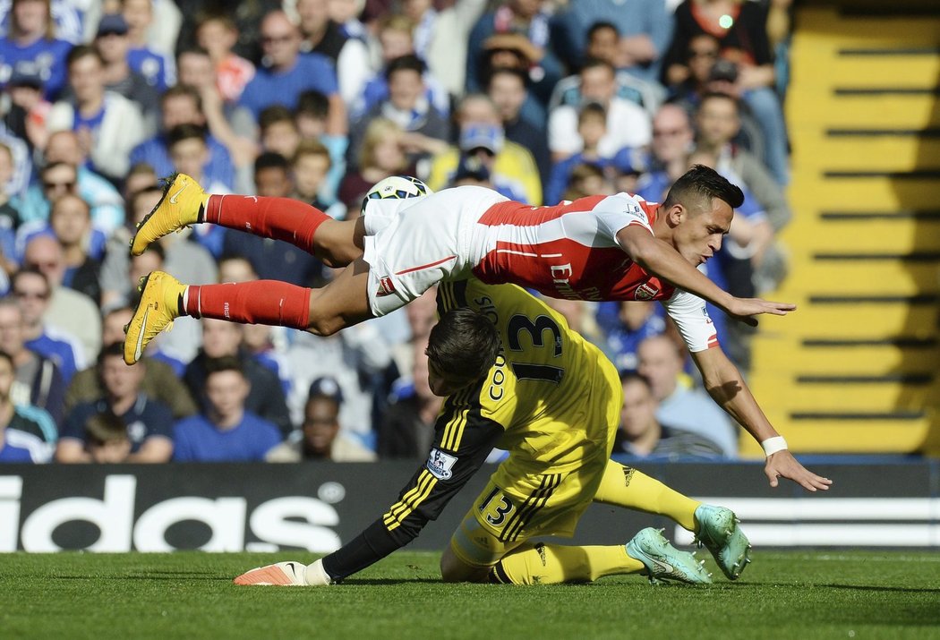 Gólman Chelsea Thibaut Courtois při srážce s útočníkem Arsenalu Alexisem Sánchezem