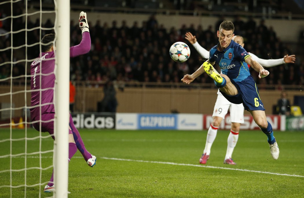 Obránce Arsenalu Laurent Koscielny v akrobatické poloze pálí na branku Monaka