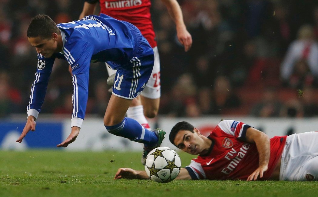 Arteta ze země přihlíží, jak za míčem běží Ibrahim Afellay ze Schalke 0:4. V utkání Ligy mistrů Arsenal prohrál 0:2