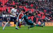 Petr Čech podklouzává a ve skluzu odehrává balon před Harry Kanem v utkání s Tottenhamem