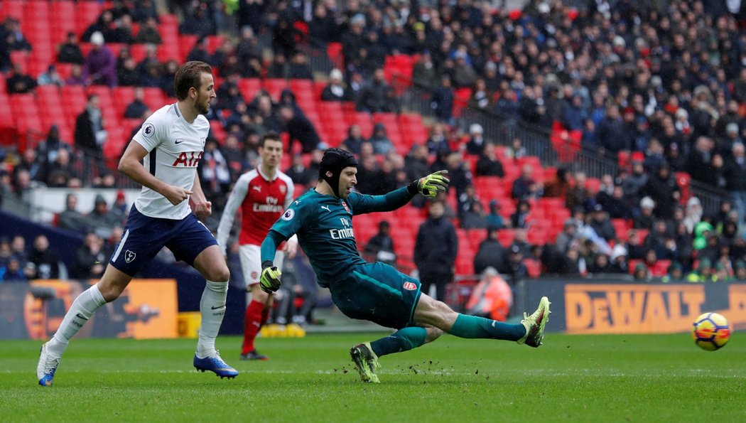 Petr Čech podklouzává a ve skluzu odehrává balon před Harry Kanem v utkání s Tottenhamem