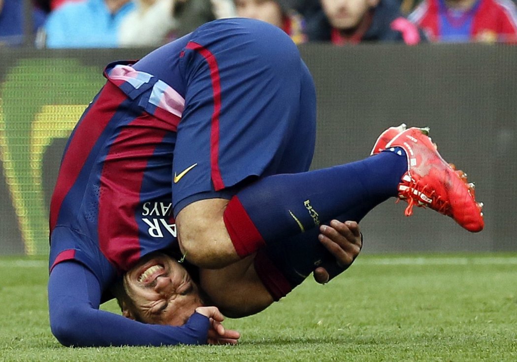 Luis Suárez leží po tvrdém zákroku obránců v zápase s Málagou