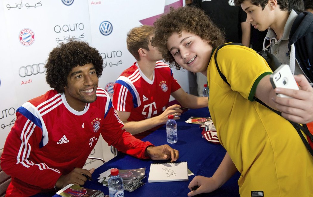 Mnichovští fotbalisté Dante a Thomas Müller na autogramiádě bavorského velkoklubu v Kataru.