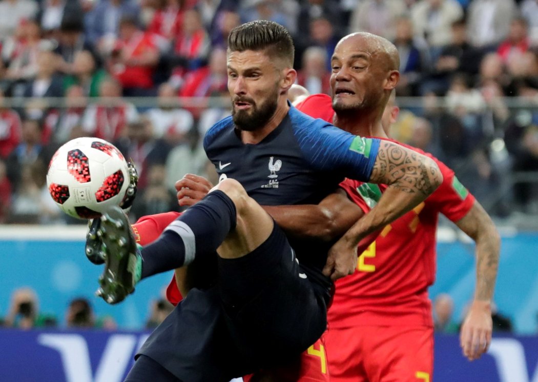 Olivier Giroud se během semifinále MS snaží pokrýt míč před zkušeným stoperem Belgie Vincentem Kompanym