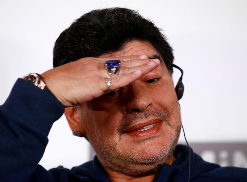 Diego Maradona gestikuluje na tiskové konferenci v Brestu. Jako dárek dostal obří modrý prsten...