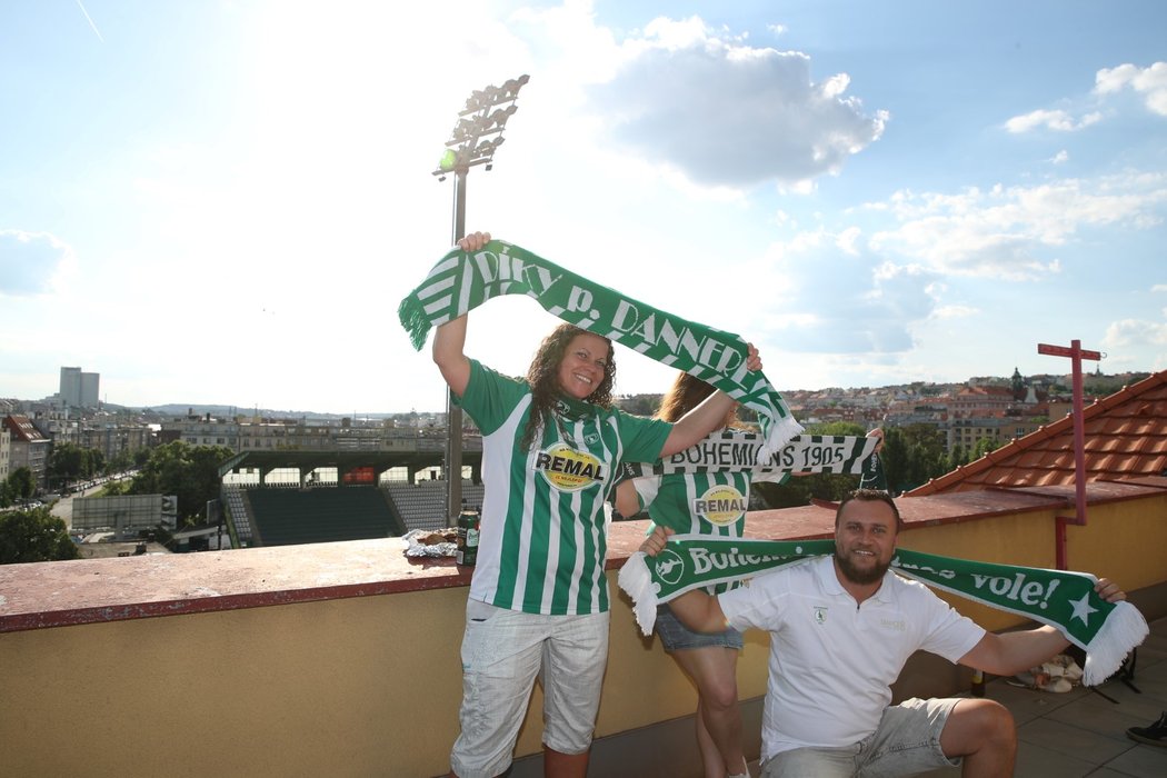 Fanoušci Bohemians sledují ze střechy přilehlé budovy u stadionu utkání proti Teplicím