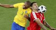 Srb Alexandr Mitrovič se snaží pokrýt míč v souboji s Brazilcem Mirandou