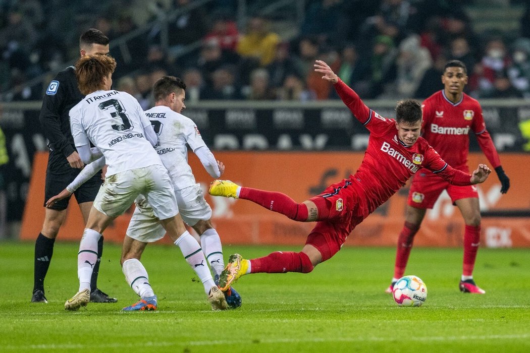 Adam Hložek padá po jednom ze soubojů během zápasu s Mönchengladbachem
