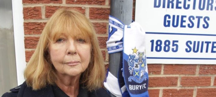Joy Hartová, bývalá ředitelka Bury a dcera klubové legendy Lese Harta, po němž je dokonce pojmenována jižní tribuna stadionu, se připoutala přímo u hlavního vstupu na protest proti současnému majiteli, který nehodlá krachující klub prodat