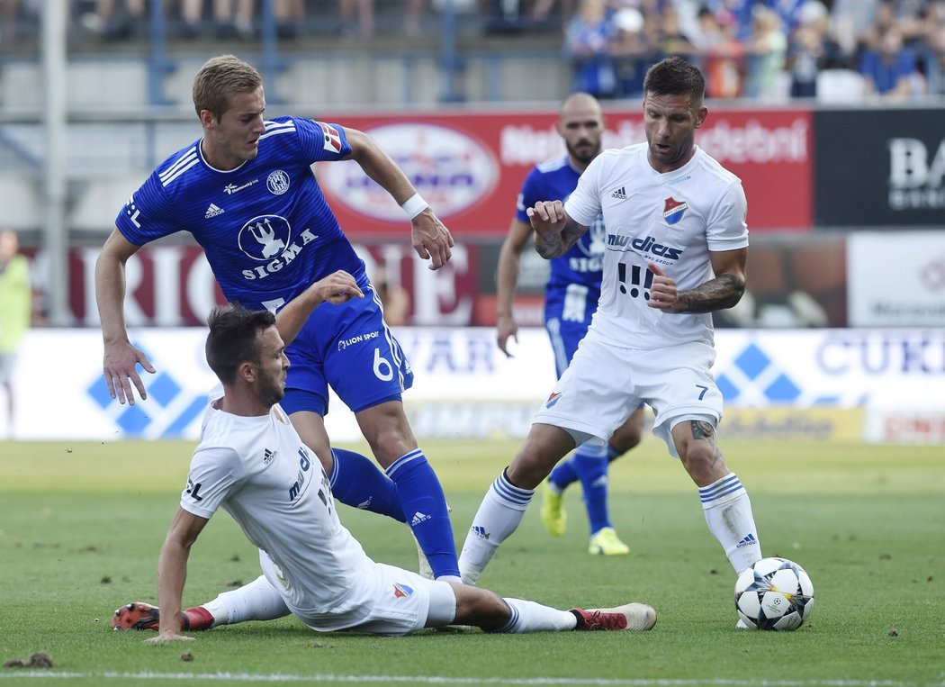 Lukáš Pazdera skluzuje proti Jakubu Plškovi v souboji Baníku Ostrava s Olomoucí