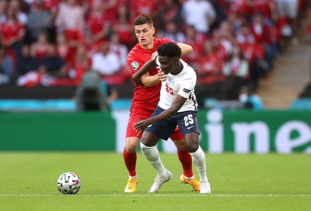 Anglický útočník Bukayo Saka se snaží prosadit přes dánskou obranu v semifinále EURO