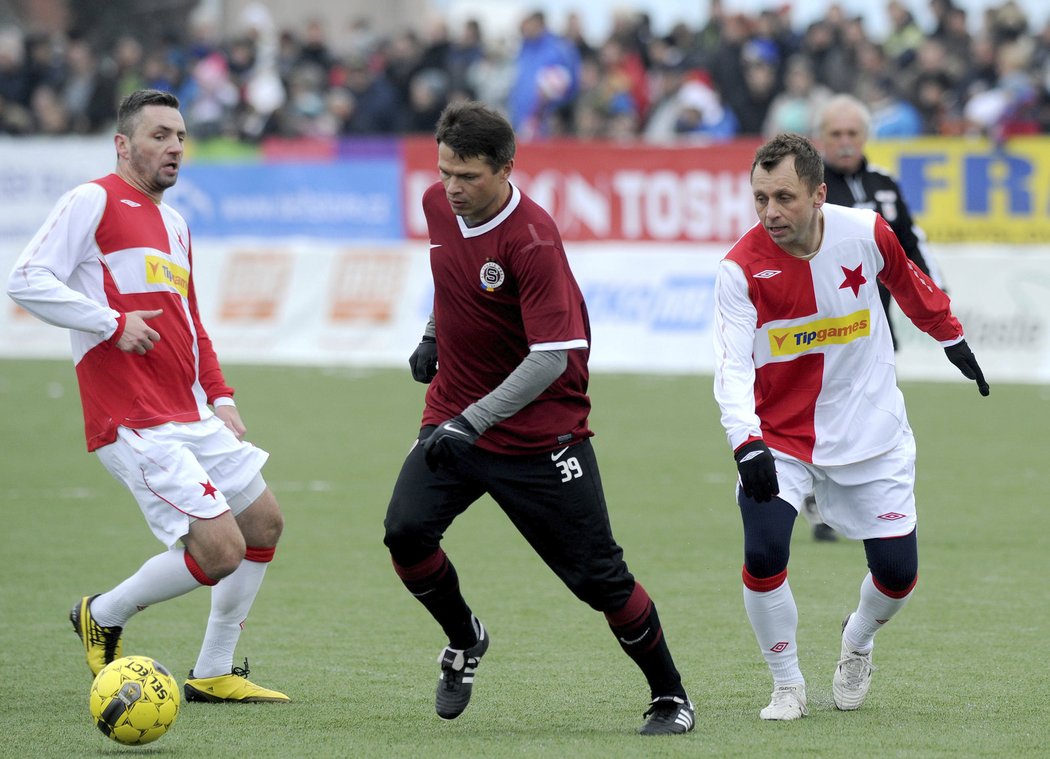 Sparťan Libor Sionko proniká s míčem v obležení dvou hráčů Slavie během silvestrovského derby v Edenu. Sparta vyhrála 6:3.