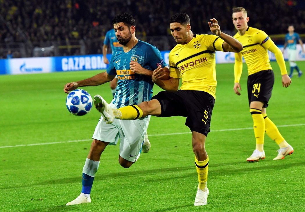 Obránce Dortmundu Achraf (vpravo) v souboji s Diegem Costou z Atlétika