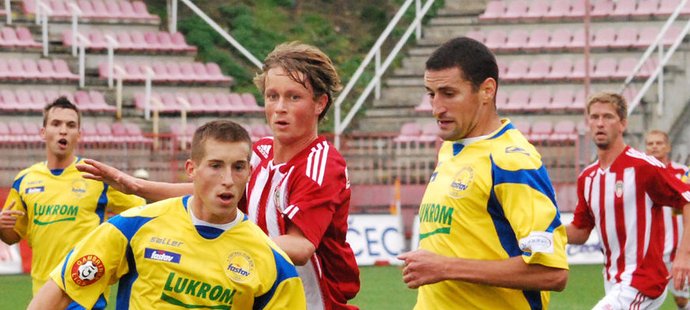 Zlínští Lukáš Salachna (vlevo) a Pavel Elšík se snaží uklidit míč do bezpečí před Martinem Surynkem ze Žižkova