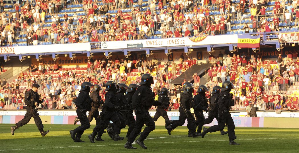 Jednotka policejních těžkooděnců zasahuje proti fanouškům Sparty, kteří po derby vtrhli na hřiště