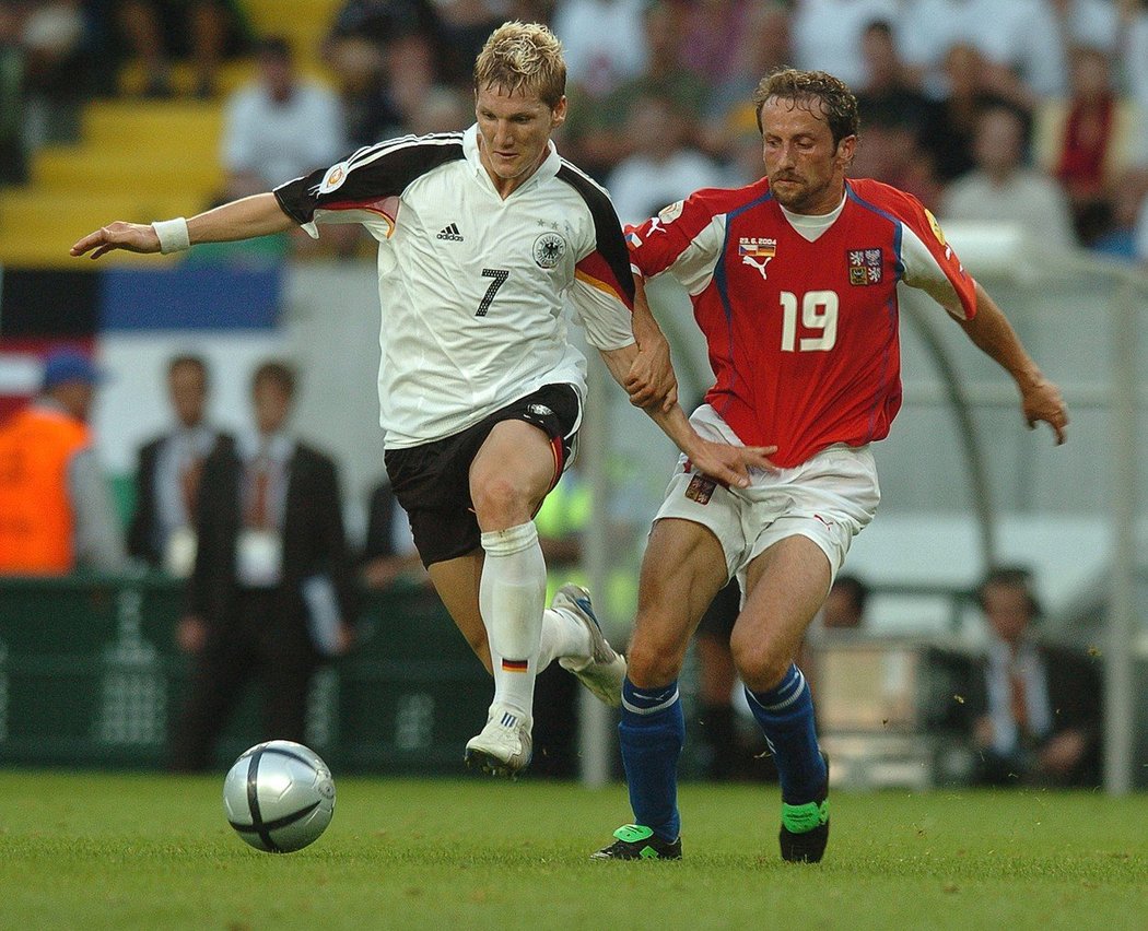 Roman Týce se pokouší zastavit německého záložníka Bastiana Schweinsteigera během zápasu základní skupiny EURO 2004, který Češi nakonec vyhráli 2:1