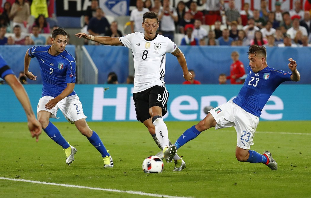 Mesut Özil právě střílí do sítě Itálie gól, po němž Německo vedlo ve čtvrtfinále EURO 1:0.