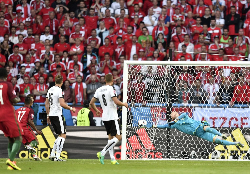 Rakouský brankář Robert Almer likvidu ránu Portugalce Naniho během utkání EURO 2016.