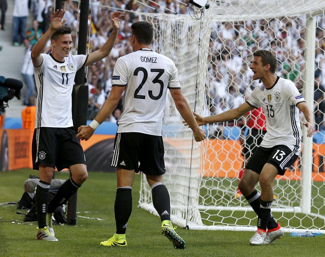 Julian Draxler (vlevo) se raduje se střelcem druhé branky Mario Gómezem (uprostřed) , vpravo k nim přibíhá Thomas Müller