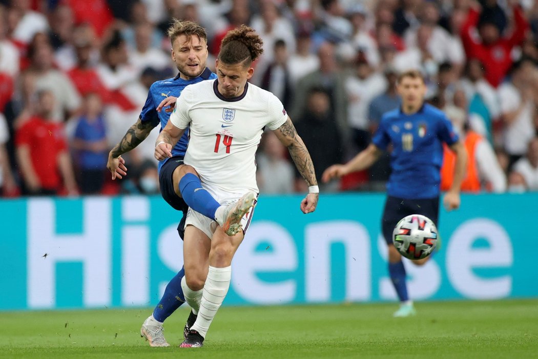 Italský útočník Ciro Immobile (vlevo) odkopává balon zpoza anglického Kalvina Phillipse během finále EURO 2021 ve Wembley